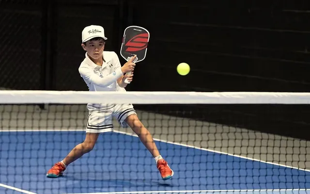 A junior player mid-swing